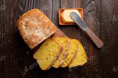 Preview: Flat lay view at homemade cornbread slices and butter on kitchen table