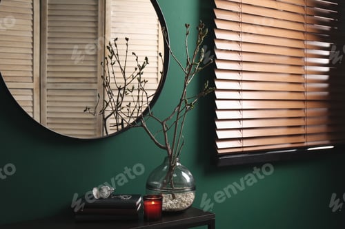 Preview: Beautiful tree twigs in vase on table near green wall