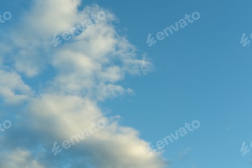 Preview: Blue sky background with white fluffy cumulus clouds. Panorama of white fluffy clouds in blue sky.