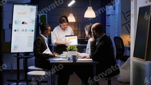 Preview: Diverse multi-ethnic businesspeople analyzing management graphs using tablet