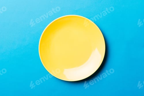 Preview: Top view of isolated of colored background empty round yellow plate for food