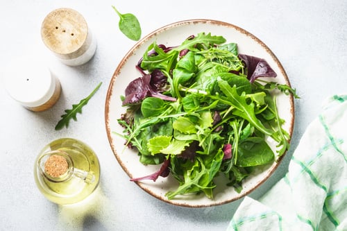Preview: Salad from green leaves and vegetables on white.