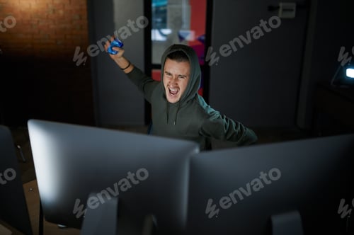 Preview: Mad male hacker in hood sitting at screens, back view