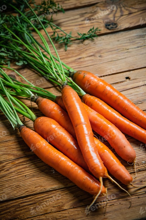 Preview: Fresh carrots on wooden table.