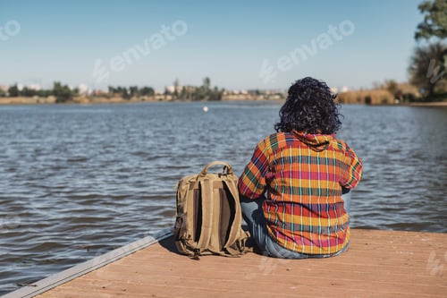 Preview: Woman enjoying freedom contemplating nature by lake