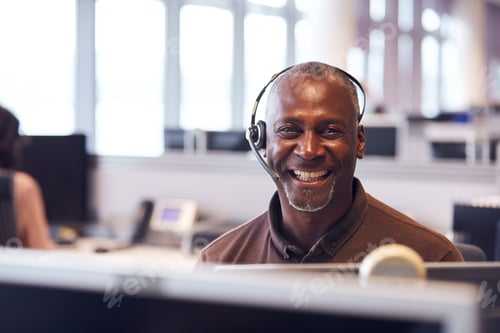 Preview: Portrait Of Mature Businessman Wearing Telephone Headset Working In Customer Services Department