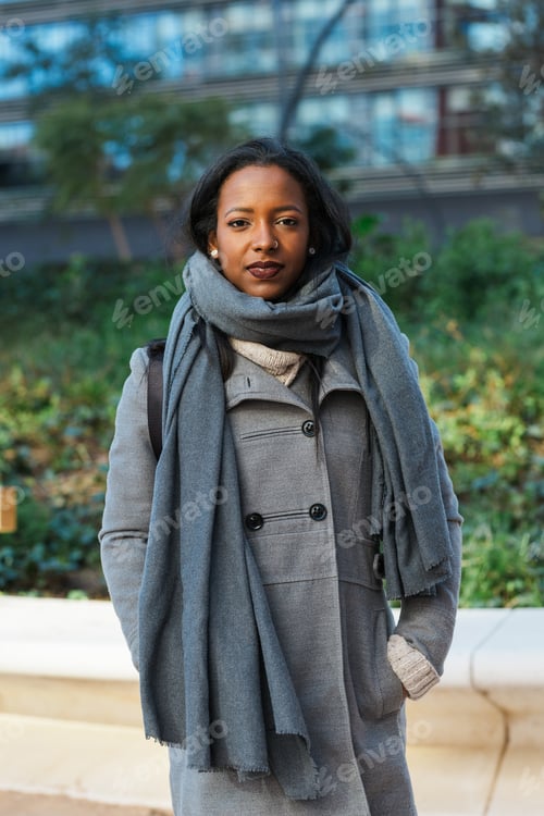 Preview: Business woman looking at camera while standing on the street at financial district