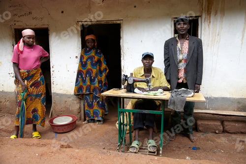 Preview: Tailor with his customers waiting outside his workshop