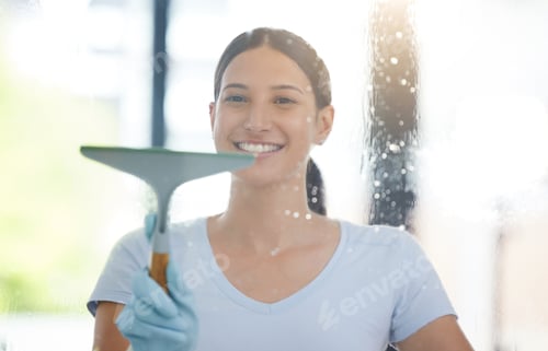 Preview: Portrait of a happy mixed race domestic worker using a squeegee on a window. One Hispanic woman enj
