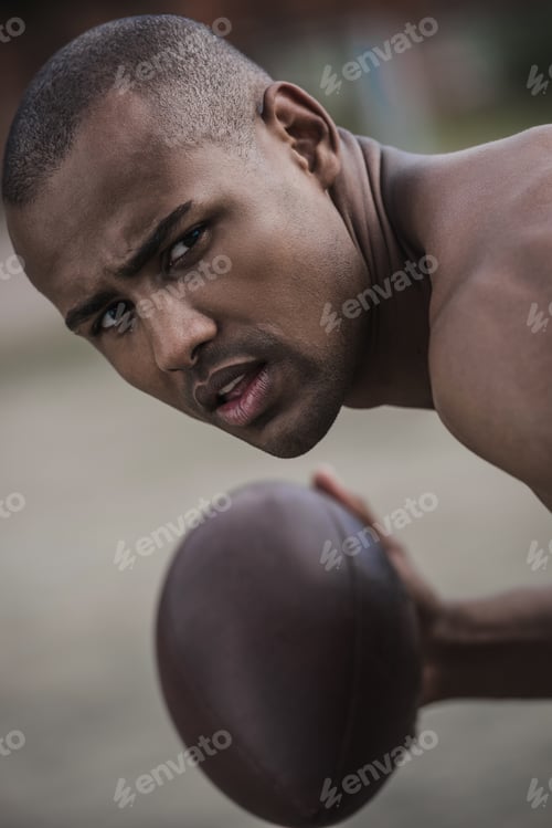 Preview: young handsome african american male football player with ball