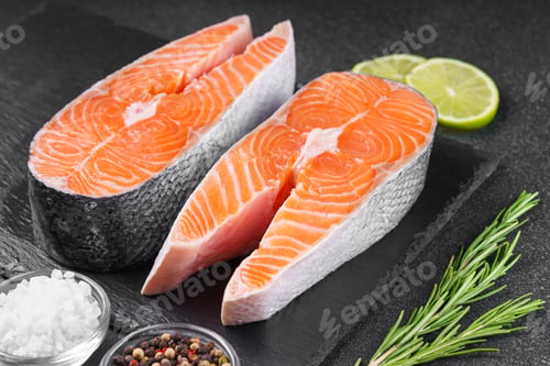 Preview: Two Fresh Raw Salmon, Trout Steak With Spices, Rosemary And Lime On Black Stone Background