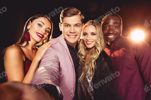 Preview: smiling glamorous young multiethnic friends taking selfie