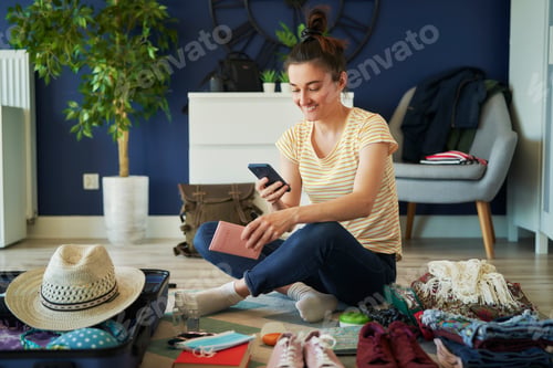 Preview: Happy woman using phone during preparing to travel