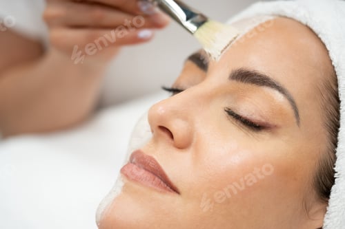 Preview: Aesthetics applying a mask to the face of a Middle-aged woman in modern wellness center