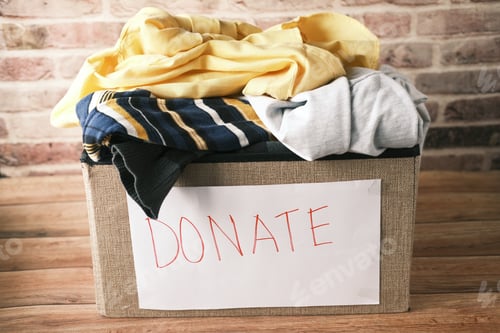 Preview: Donation box with donation clothes on a wooden table .