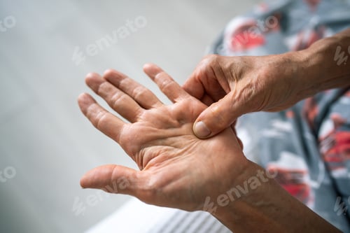 Preview: Unseen old woman rubs, feels tender hand with stiff knot under ring finger. Dupuytren contracture