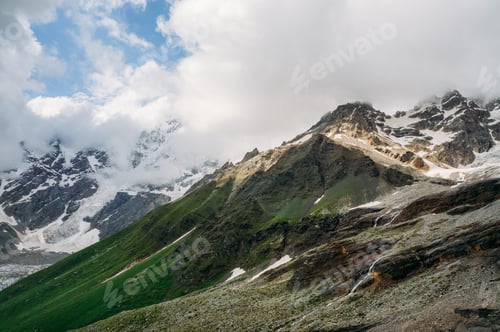 Preview: view of snowy mountain peaks with grass on slopes under clouds, Ushguli, svaneti, georgia