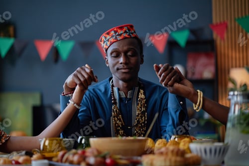 Preview: Young Black Man Holding Hands with Family Celebrating Kwanzaa Tradition