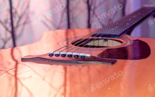 Preview: Acoustic guitar on a beautiful colored background. The concept of stringed instruments.