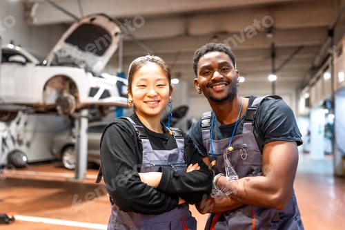 Preview: Portrait of confident mechanics smiling in auto repair shop