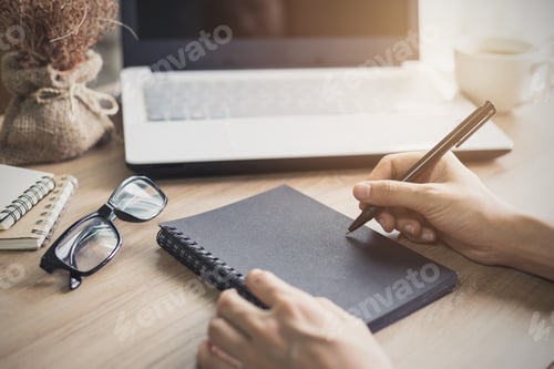 Preview: woman writing on notebook at workplace