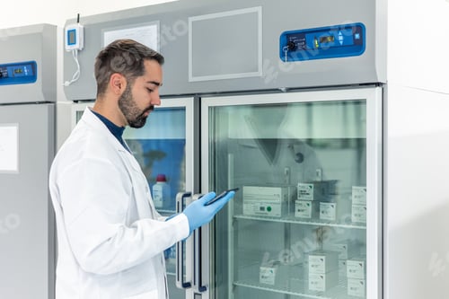 Preview: Scientist using tablet checking refrigerated drugs in pharmaceutical laboratory refrigerator