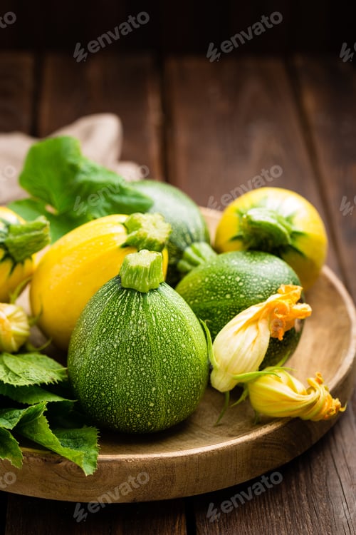 Preview: Zucchini with leaves and flowers on dark wooden rustic background