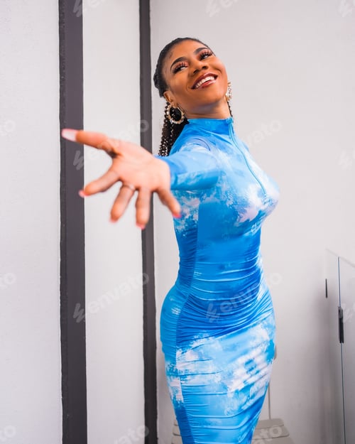 Preview: Fashion lifestyle of a black ethnic girl with collected hair and a blue dress