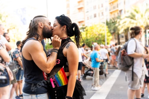Preview: Couple kissing at gay pride parade showing rainbow flag