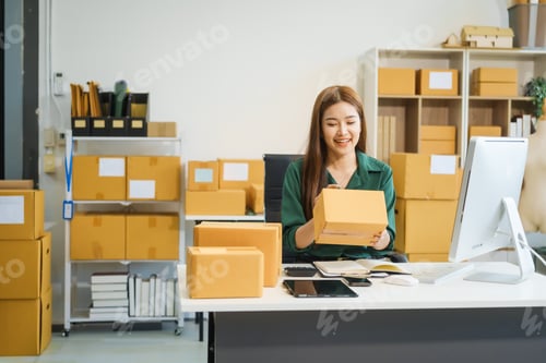 Preview: An Asian businesswoman sits at her desk, working on online sales e-commerce marketing strategies