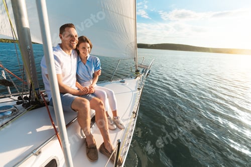 Preview: Smiling Couple Embracing Sitting On Yacht Deck Looking At Seascapes
