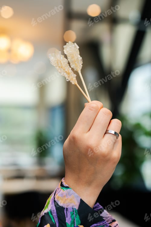 Preview: Closeup of hand holding stick of rock candies