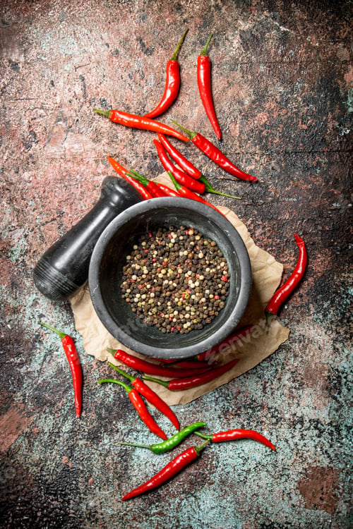 Preview: Fresh pepper peas in a mortar with pestle and hot pepper in a pod.