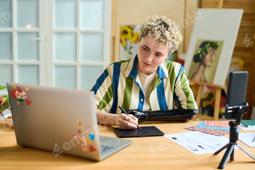 Preview: Young female graphic designer and blogger with arm prosthesis creating drawing