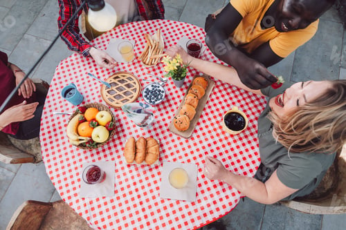 Preview: top view of a round table prepared for breakfast with multiethnic people enjoy the company