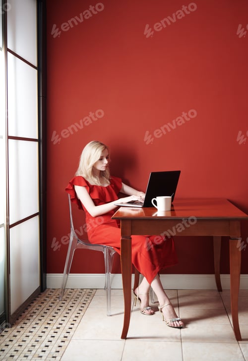 Preview: Woman in Red Dress Working on Laptop