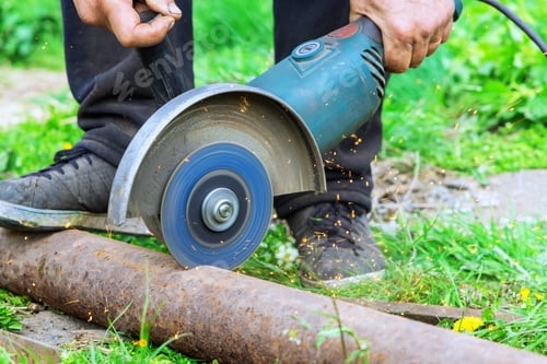 Preview: When cutting metal frame, worker uses an angle grinder hand saw for a cutting metal