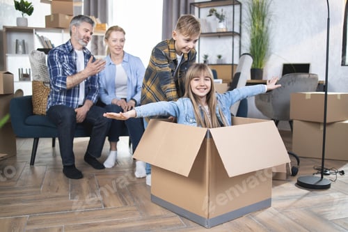 Preview: Two kids playing with boxes while parents relaxing on sofa at modern appartment