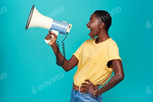 Preview: Studio shot of a young woman using a megaphone against a turquoise background