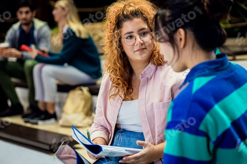 Preview: Diverse group of student siting in campus learning together.