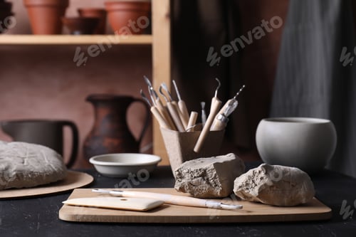 Preview: Clay and set of modeling tools on table in workshop