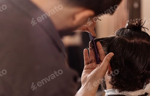 Preview: Hairdresser cutting hair of man