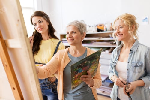 Preview: women with easel and palettes at art school