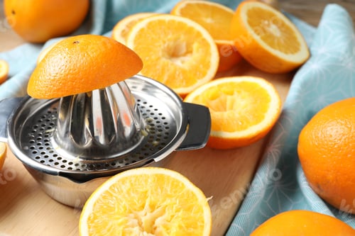 Preview: Squeezer and oranges on wooden table, closeup. Making fresh juice