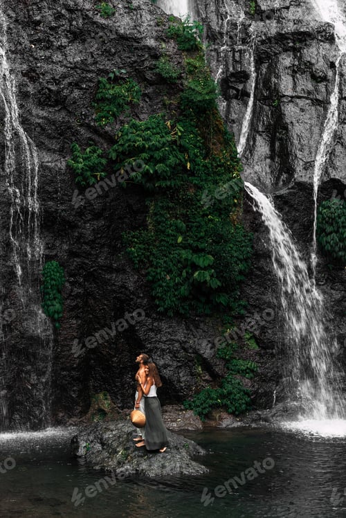 Preview: A beautiful girl embraces a man of athletic build at the waterfall