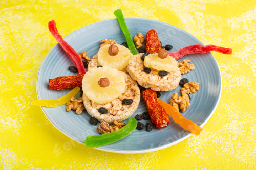 Preview: front view dried fruits pineapple rings walnuts and nougat inside blue plate on the yellow
