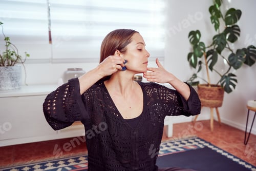 Preview: caucasian woman massaging her face with manual quartz massager
