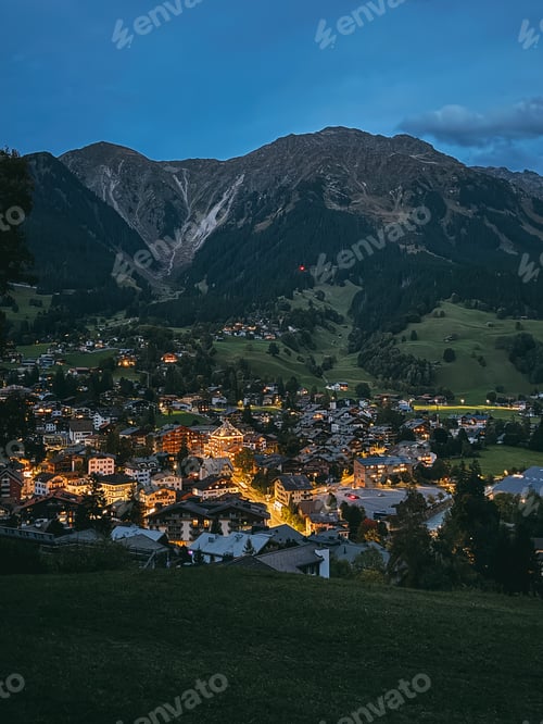 Preview: Alpine village illuminating valley at dusk reflecting tranquil evening light