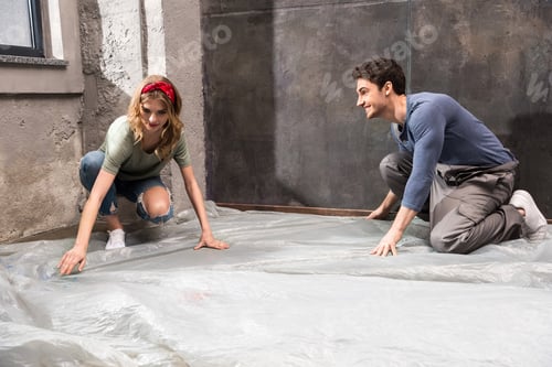 Preview: Smiling young professional couple preparing room for renovation home