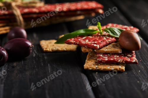 Preview: Beetroot and rye flour crackers with vegetables for making snacks on a black background.